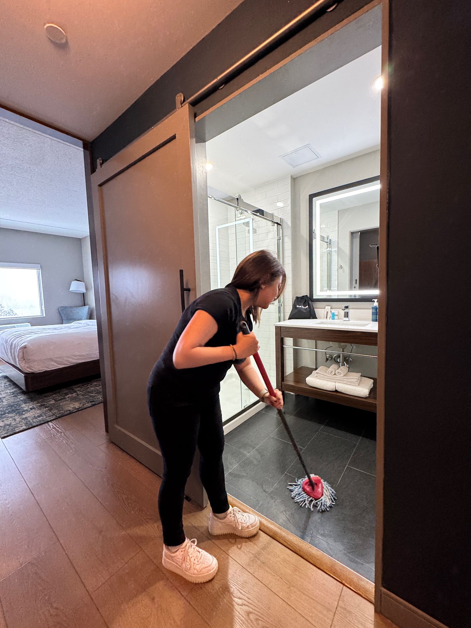Housekeeper mopping hotel bathroom